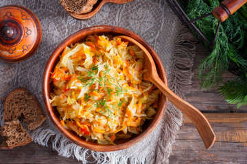 Braised cabbage in a wooden bowl, top view, selective focus