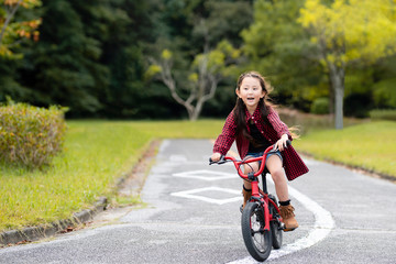 赤い自転車に乗る女の子