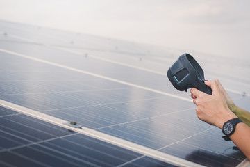 woman engineer checking heat of solar panel and using ir camera to scan heating of panel at solar...