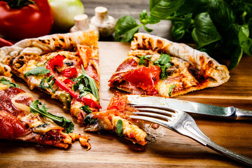 Pizza with pepper,salami and champignon on wooden table