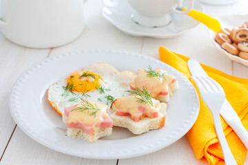 Breakfast with fried egg and hot sandwiches with sausage and cheese, horizontal