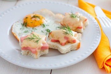 Breakfast with fried egg and hot sandwiches with sausage and cheese, horizontal