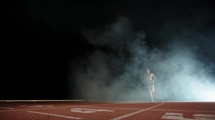 Athlete running on short track. Young south asian runner heading forward on track of sports arena, preparing for competition - fitness, sports concept