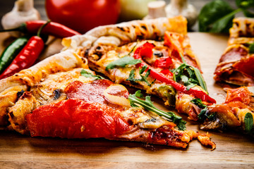 Pizza with pepper,salami and champignon on wooden table