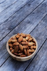 Almond nut in wooden bowl on wood table background, copy space