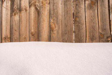 Background of a snowdrift and a wooden fence