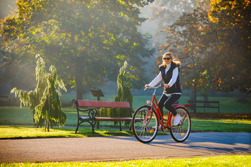 Urban biking - woman riding bike in city park