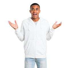 Fototapeta premium Dark-skinned young man with white sweatshirt with surprise and shocked facial expression. Mouth open because not expect what has happened on isolated white background