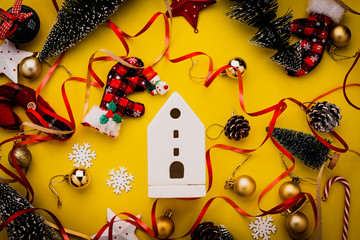 festive celebration background with christmas decorating items on yellow paper background with free copy space for your text