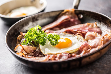 Close-up roasted bacon and egg with herbs.