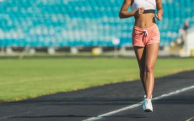 Fototapeta na wymiar Female athlete feet running on the running track on a sunny day
