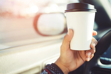 people person drinking paper cup coffee of hot holding hand in a car in the morning not sleepy be energetic while driving. transportation and vehicle concept. empty copy space for text.