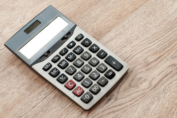 white screen calculator on a wooden desk.