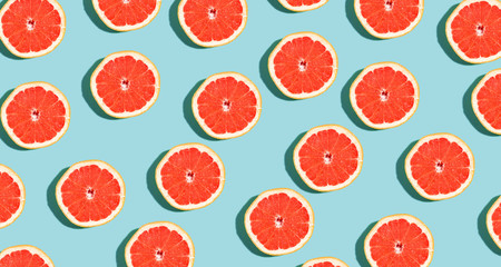Halved fresh grapefruits on bright color background