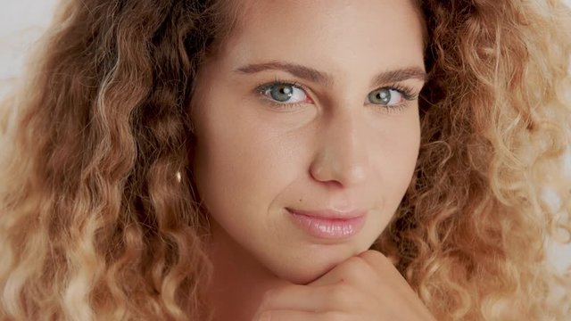beauty blonde curly hair model looking at camera send a kiss to the camera and smiling. Closeup slowmotion 60 fps