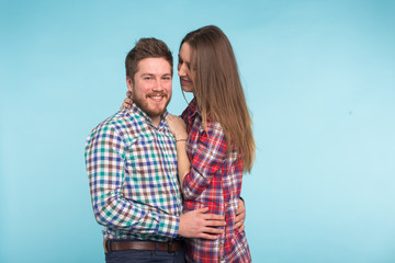Portrait of cheerful laughing funny young lovers fooling around on blue background
