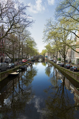 Fototapeta na wymiar bridges over canal with mirror reflections of spring trees in water, Amstardam, Netherlands