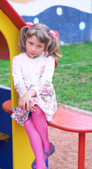 Little Caucasian child girl looking seriously being on the playground. - 228861197