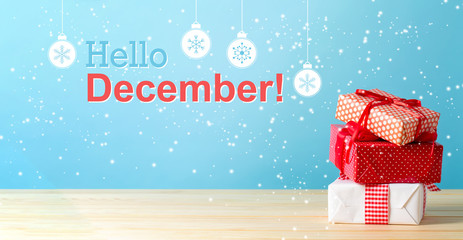 Hello December message with Christmas gift boxes with red ribbons