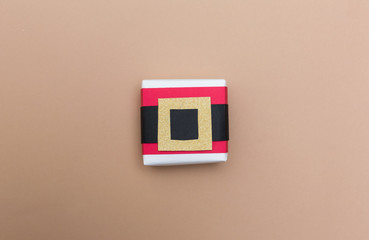 Santa belt gift box on a light brown paper background