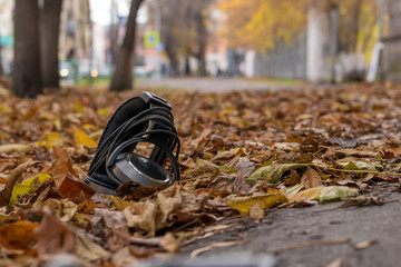 audio old headphones lying in the street in autumn yellow foliage