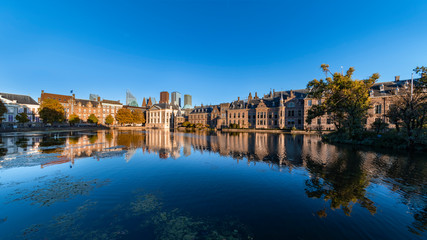 Reflection of the Buitenhof, Binnenhof buildings, Dutch parliament campus under a clear blue sky in The Hague, Netherlands