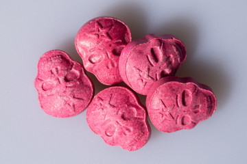 A pile of Red Army Skull, Ecstasy, XTC pills on a grey background.