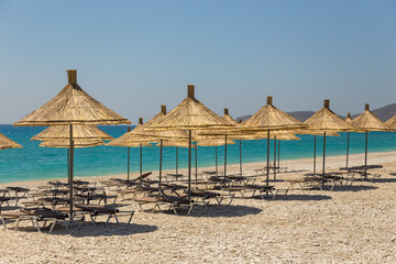 Umbrellas on the Borsh Beach in Albania. Stony beach on the Adriatic Sea.