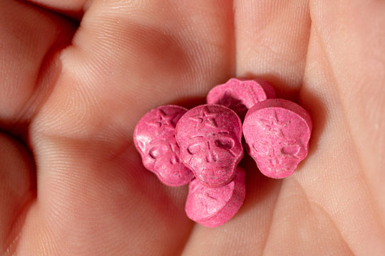 Red Army Skull, Ecstasy, pain killer or xtc pills in the palm of a caucasian hand. 
