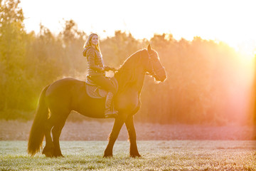 Obraz na płótnie Canvas Woman riding a horse in park