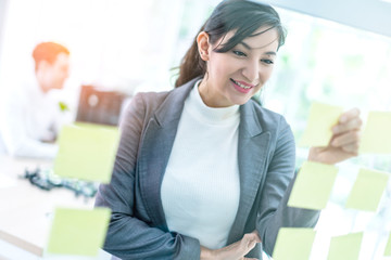 smart attractive businesswoman brain storm with yellow paper note office background