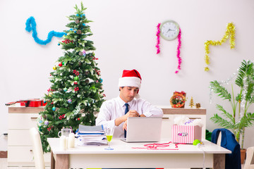 Obraz na płótnie Canvas Employee businessman celebrating christmas in office