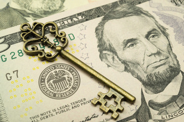 Key on US dollars banknote near Federal Reserve System (FED) seal. Concept of control economy...