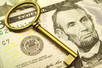 Key on US dollars banknote near Federal Reserve System (FED) seal. Concept of control economy...