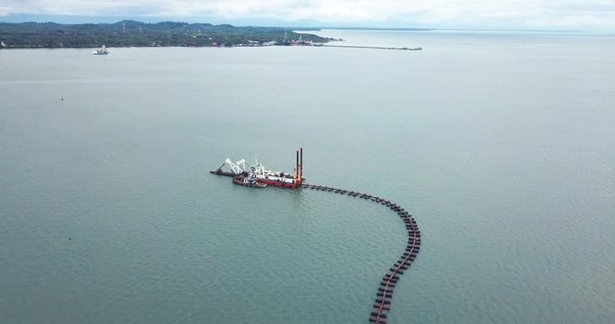 High angle view shows the coastal town a private compay 's sand extractionship  is sucking sand from the the gulf of Thailand near the Chang Island in Trad province since the company gets  a concessi