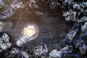 creativity ideas concept with light bulb and black color paper crumpled trash ball