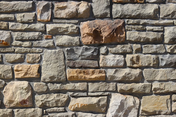 Ancient medieval stone masonry. Texture of a fragment of a wall of an old structure. A background for design and creative work. Decoration and exterior decoration of the building. Construction works.