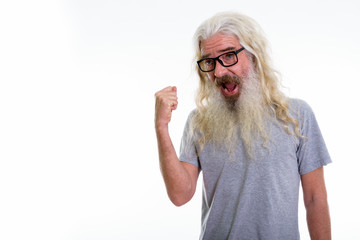 Studio shot of happy senior bearded man smiling while looking mo
