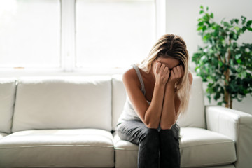 Unhappy lonely depressed woman at home living room