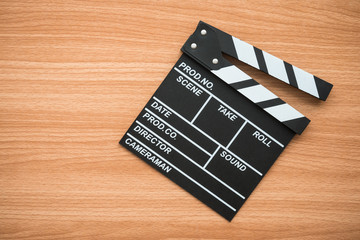 Naklejka premium Clapperboard kino na podłoże drewniane - koncepcja rozrywki filmowej