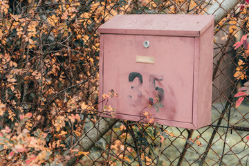 Old mailbox with number 35 on the old metal fence in a remote village