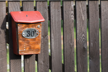 House number 30 on the mailbox on old wooden fence in a remote village