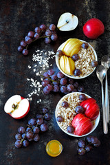 Oatmeal with honey and fruit. Porridge in bowls with apple, pear, honey and grapes. Healthy and beautiful breakfast. The concept of dietary nutrition. Superfoods