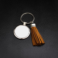 Tassel key ring on black leather background. Fashion leather key chain for decoration.