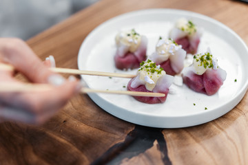 Chinese and korean dumplings on the white plate decorated with pistachio.