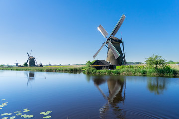 traditional dutch windmill with reflection at water, Kinderdijk at summer day, Netherland