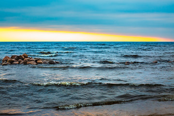 Sunset at sea. Waves and blue water. Beautiful horizon of Gulf of Finland. Sea in sunshine. Natural background.