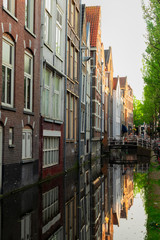 street with old houses over narrow canal in Delft old town in Holland