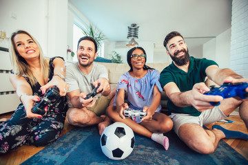 Group of friends play video games together.