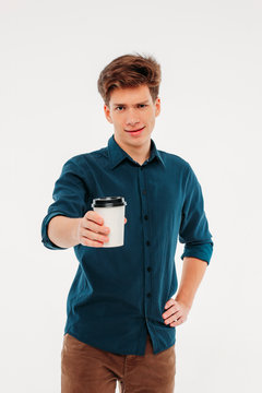 Attractive Young Man Holding A Cup Of Coffee To Go On White Back